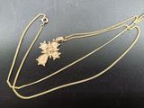a gold necklace with a cross and a flower on it