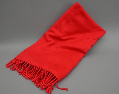 une écharpe rouge à franges sur fond gris