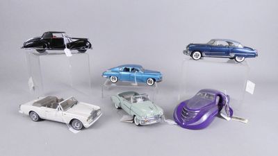 cinq modèles de voitures différents exposés dans une vitrine