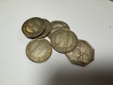 five old coins sitting on top of each other on a table