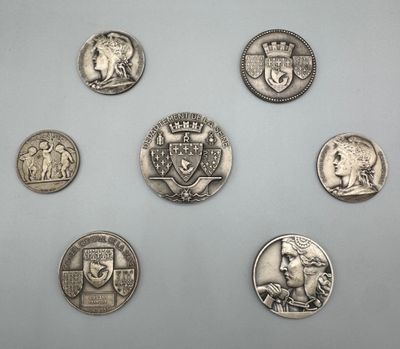 six types différents de pièces d'argent sur une surface blanche