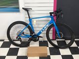un vélo bleu posé sur un sol à carreaux noirs et blancs