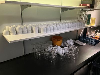 many cups and glasses on the counter in the kitchen