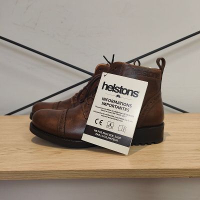 une chaussure marron avec une étiquette, posée sur une étagère