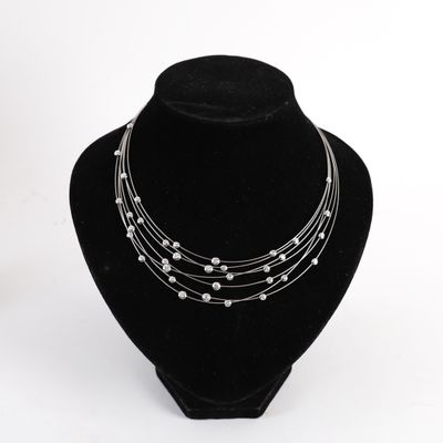 a close up of a necklace on a mannequin on a white background