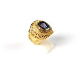 gros plan d'une bague en or avec une pierre bleue