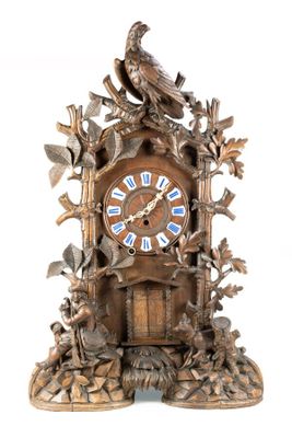 une horloge en bois surmontée d'un oiseau
