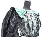 a black mannequin with a green bow on top of it