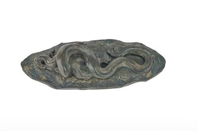 une image représentant une sculpture représentant un serpent sur un rocher