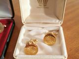two pairs of cufflinks in a box on a table