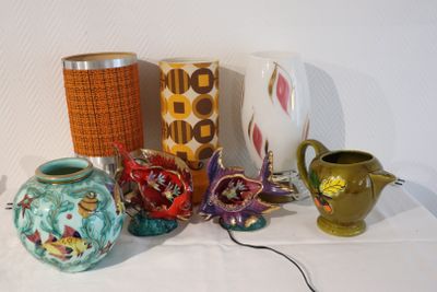 de nombreux vases et une lampe posés sur une table