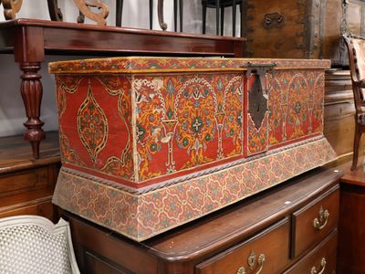 un coffre en bois posé sur une commode dans une pièce