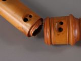 two wooden flutes with holes in them on a table