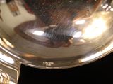 a close up of a silver watch on a black surface