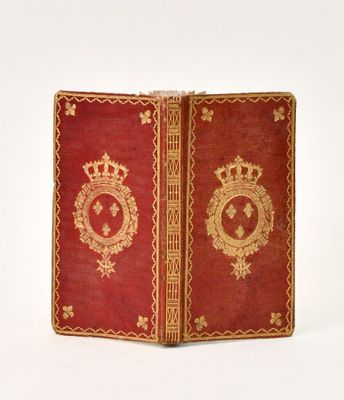 a red book with gold trim and a crown on top of it