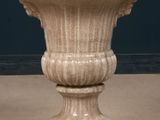 a stone vase sitting on a pedestal on the floor
