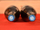 two bottles of wine sitting on a red cloth