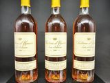 trois bouteilles de vin posées sur une table noire