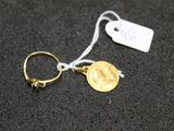 a close up of a gold ring with a coin on it