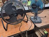 deux ventilateurs posés sur une table dans une pièce