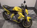 une moto jaune garée sur un sol en carrelage à damier dans une pièce