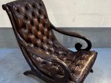 un vieux fauteuil en cuir posé sur un sol en béton
