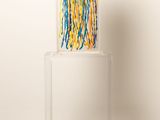 the chair is made out of plastic and has colorful yarn on it