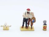 four figurines of people standing on a white surface