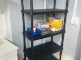 a black shelf in the corner of a room next to a sink