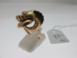 une image d'une bague en or sur une surface blanche avec une étiquette de prix