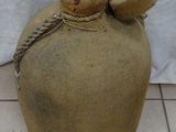 a large bottle with a rope around it on a tile floor