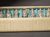 six silver figurines in a box on a table