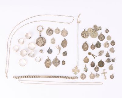 a lot of silver jewelry on a white surface