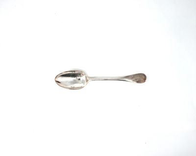 une cuillère en argent avec un manche de cuillère sur une surface blanche