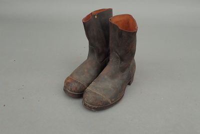 pair of brown leather boots with brown soles sitting on a white surface