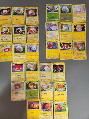 Plusieurs cartes Pokémon sont disposées sur une table devant un mur.
