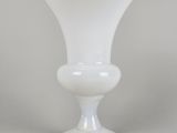un vase en verre blanc posé sur une table blanche