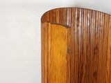 a wooden chair with a curved seat in a room
