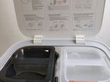 a white container with a plastic lid and a black container with a plastic lid