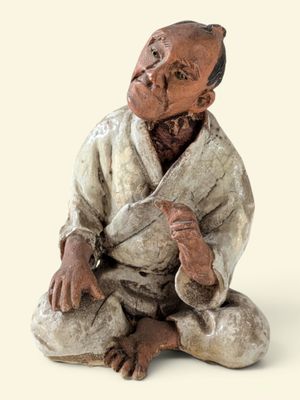 une figurine représentant un homme assis par terre