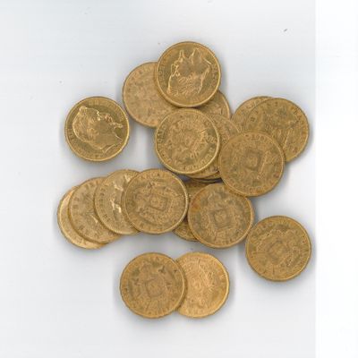 une pile de pièces d'or posée sur une surface blanche