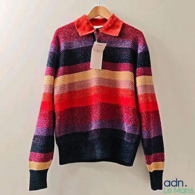 un pull coloré suspendu à un cintre accroché au mur