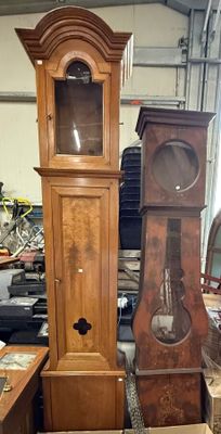 une horloge de parquet posée à côté d'une grande horloge de parquet en bois