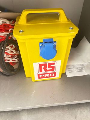 une boîte jaune avec un couvercle bleu posée sur une étagère