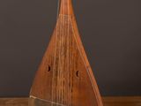 un vieil instrument en bois posé sur un parquet en bois dur