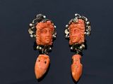 une photo d'une paire de boucles d'oreilles sur lesquelles est représenté un visage