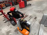 a forklift in a warehouse with other forklifts in the background