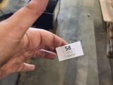 a hand that is holding a piece of paper in front of a pile of wood