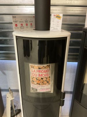 un poêle noir et blanc sur lequel est collé un autocollant