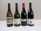 four bottles of wine are lined up on a table